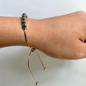 Emerald green jewels and golden bracelet